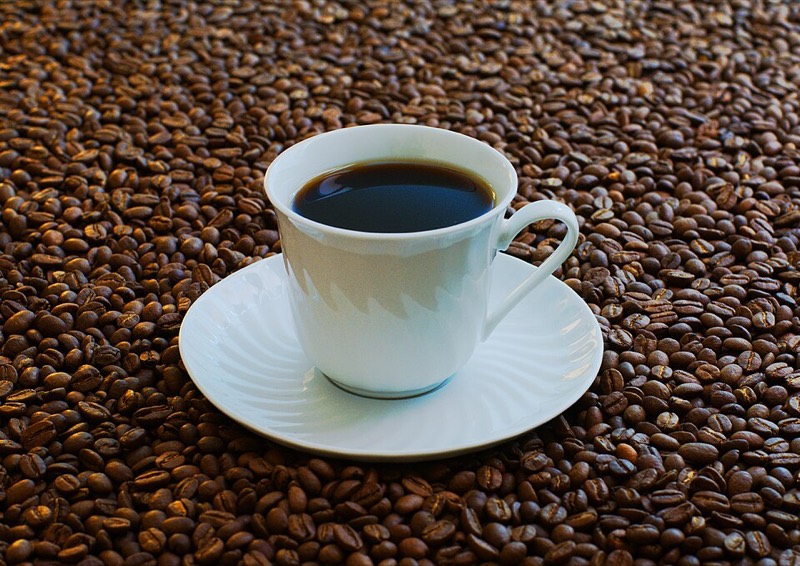 A cup of coffee with coffee beans
